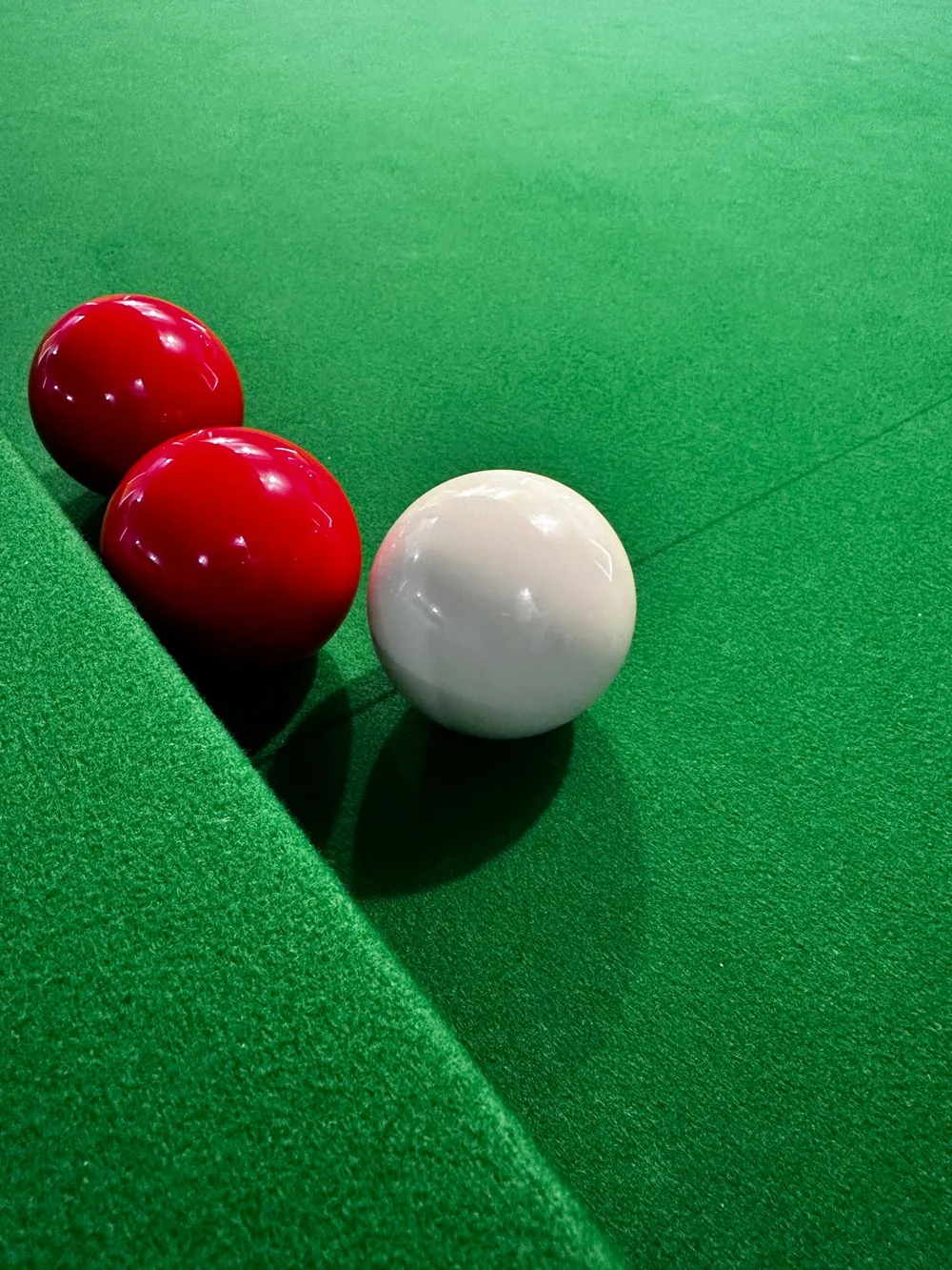 Red and white snooker balls resting on the green baize